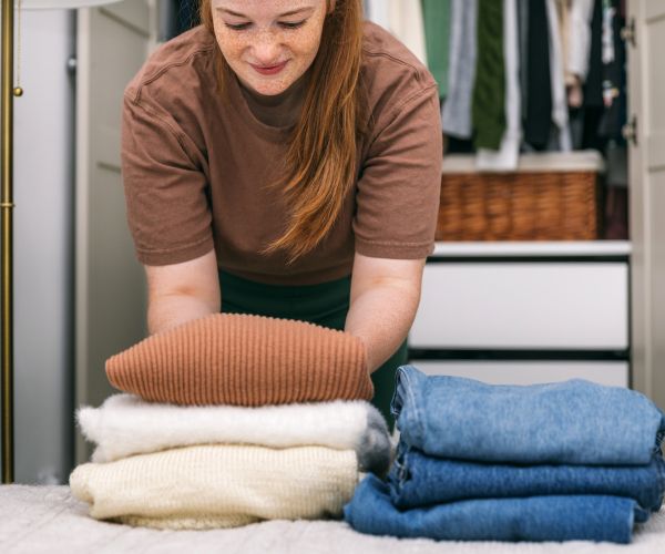 woman folding laundry with in unit washer and dryer
